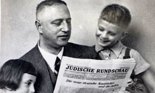 Mann und 2 Kinder lesen Zeitung "Jüdische Rundschau"