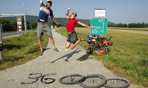 Andreas Hübl und Anita Burgholzer springend vor einer 36000 gelgeten Zahl aus Fahrradreifen