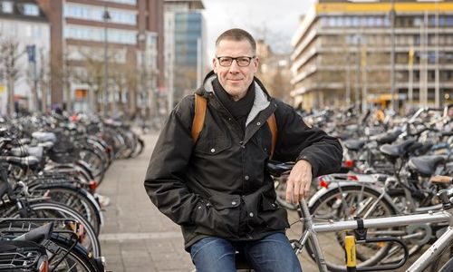 Pro. Dr. Niko Paech sitzt auf Fahrrad; drumherum sind noch mehr Fahrräder
